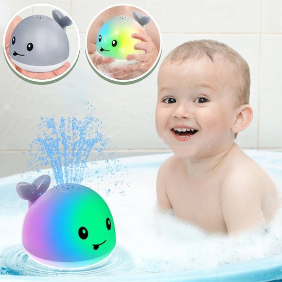 garcon souriant dans bain avec jouet de bain baleine lumineuse