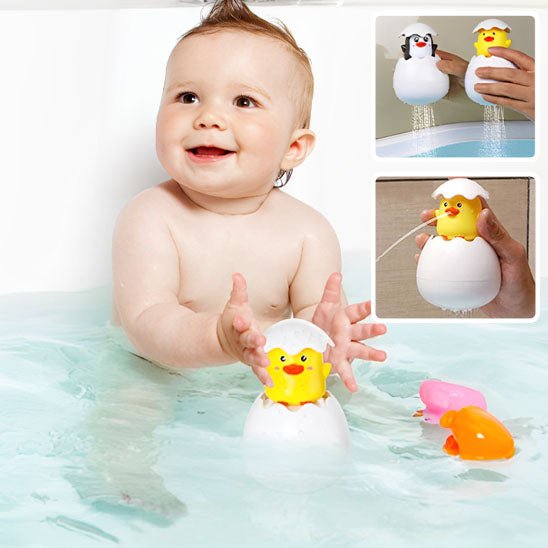enfant heureux jouant avec jouet de bain poussin et pingouin